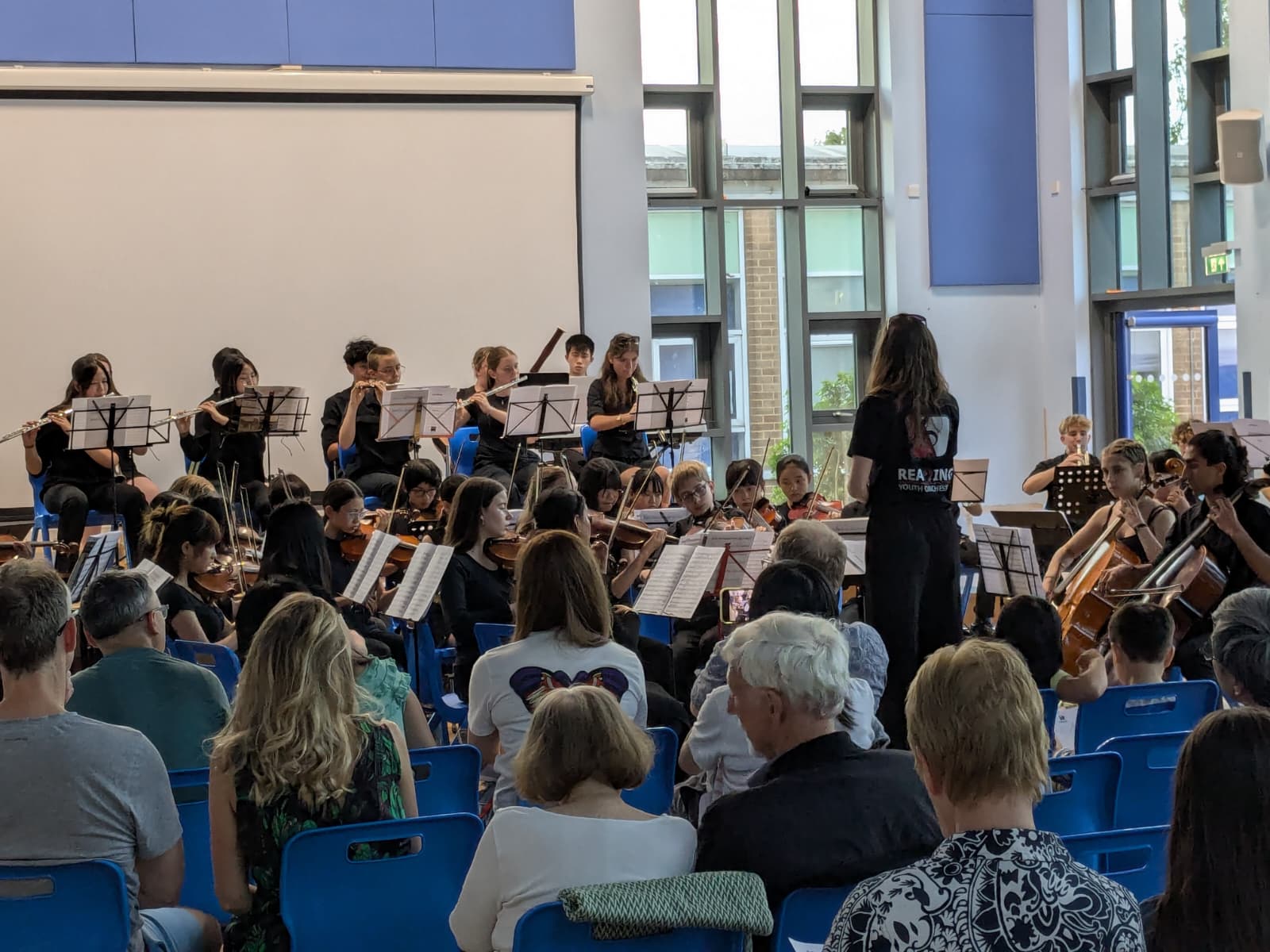 Image shows an orchestra playing in front of an audience